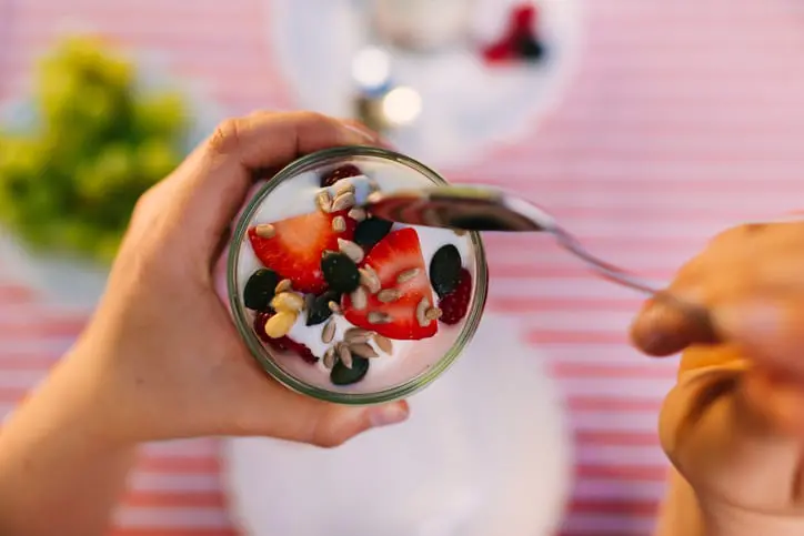 holding a glass of overnight oats.